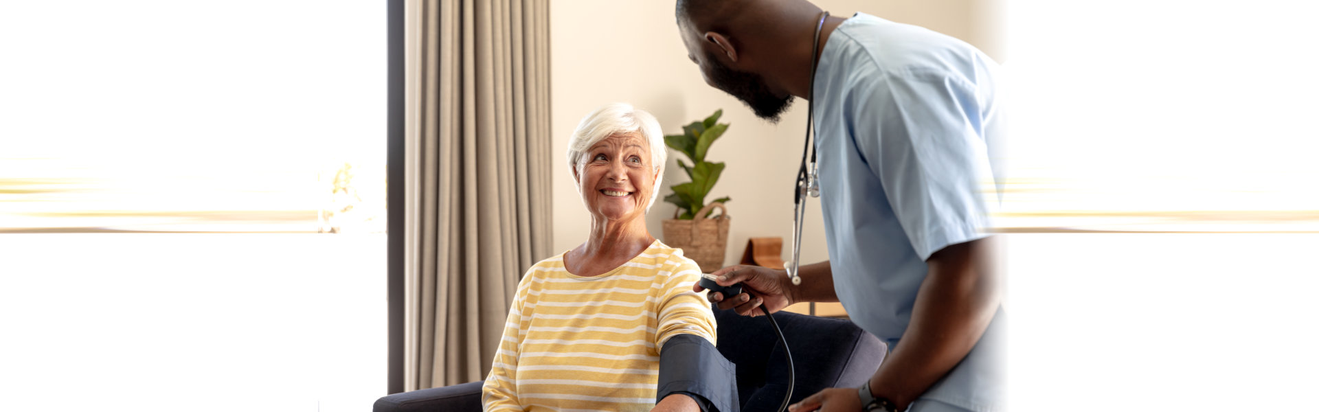 Caregiver taking blood pressure of elderly woman