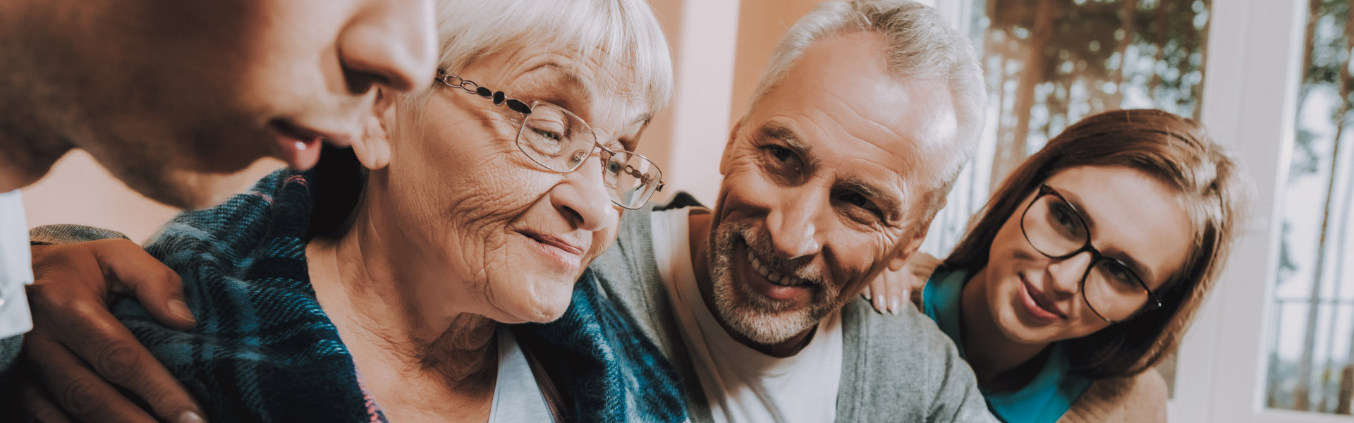 Senior smiling with caregiver, sharing a joyful moment.
